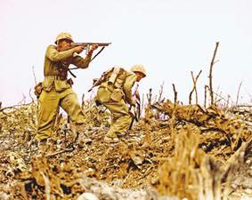 Dua orang Marinir bersenjatakan senapan otomatis menyerang posisi pasukan Jepang di Okinawa.